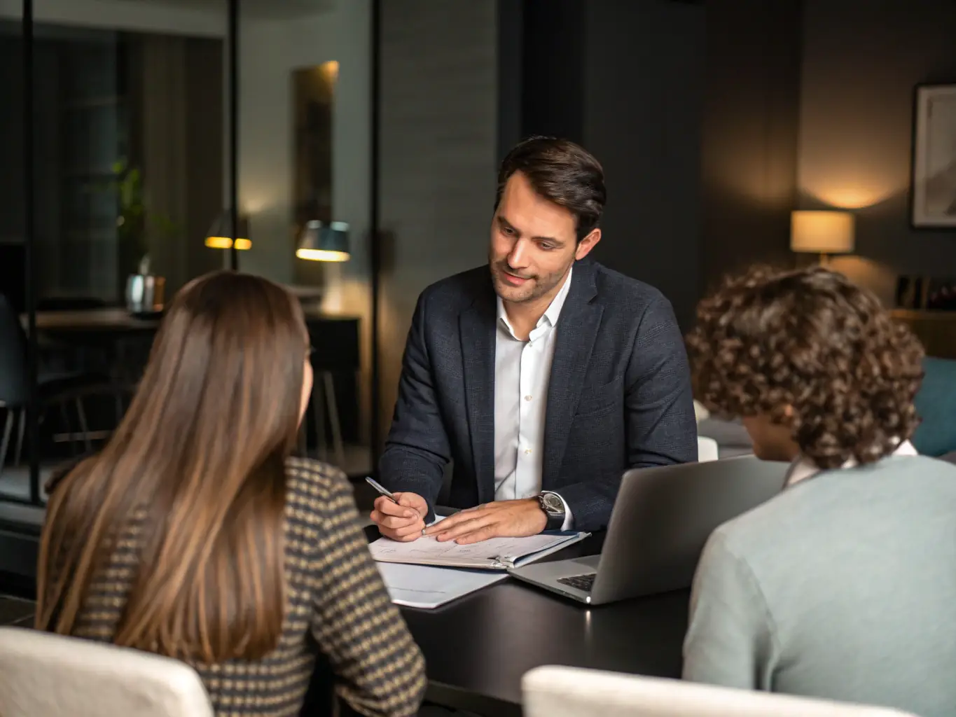 A consultant working closely with a client, reviewing financial documents and discussing investment strategies in a modern office setting, symbolizing personalized service.